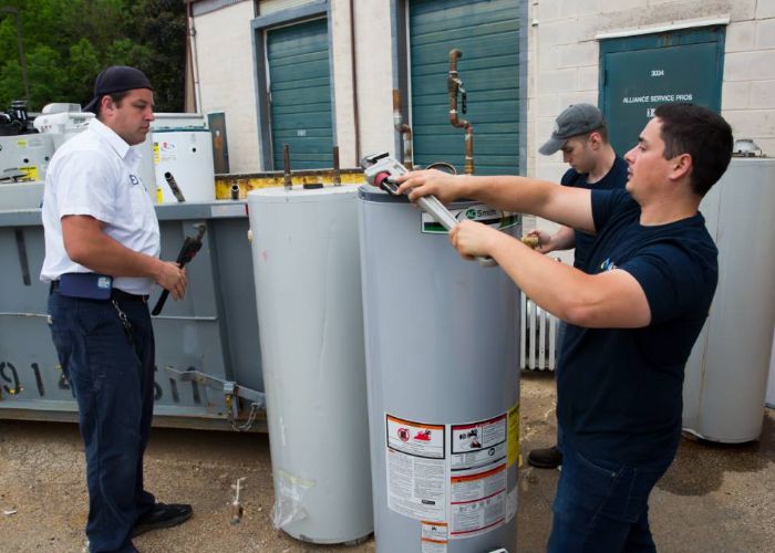 Plumbers from Alliance Service Pros repairing and installing water heaters in Monroe Township, showcasing professional plumbing services.